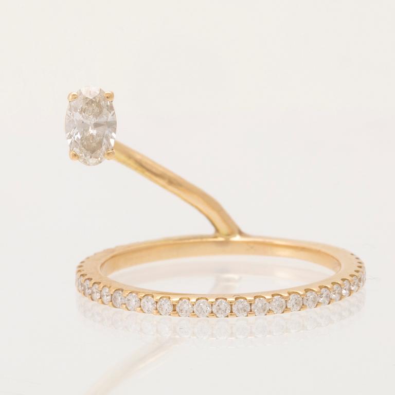 An 18K gold ring set with an oval cut and round brilliant cut diamonds by LWL Jewelry.