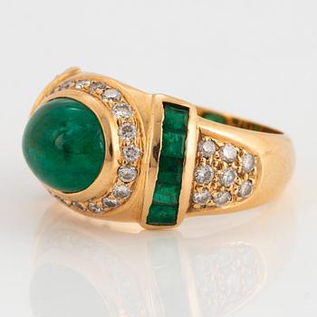 An 18K gold ring set with a cabochon-cut emerald.