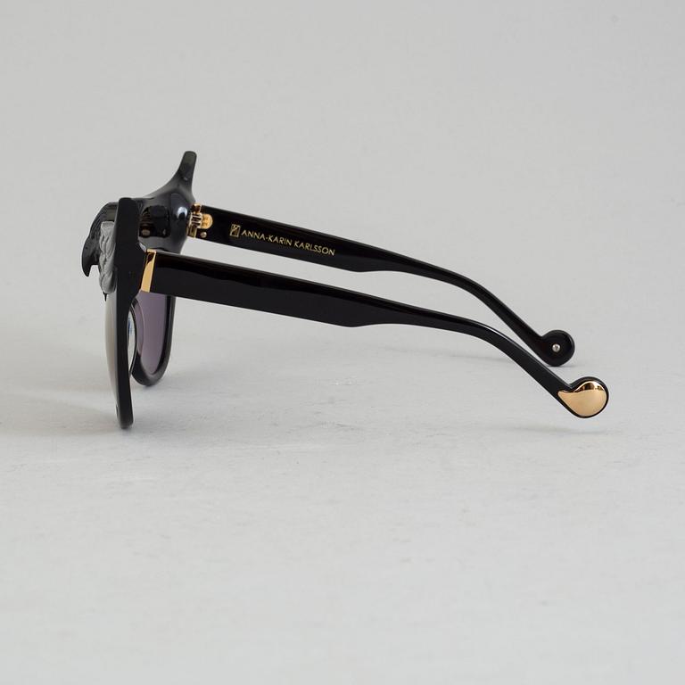 A pair of Anna-Karin Karlsson sunglasses.