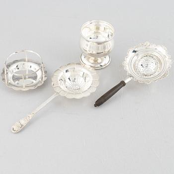 Two sterling silver tea strainers with stands, 20th century.