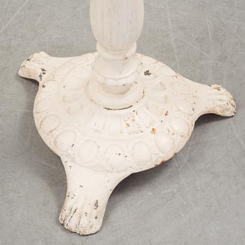 A pair of cast iron chais with wooden seats and a cast iron table, early 20th century.