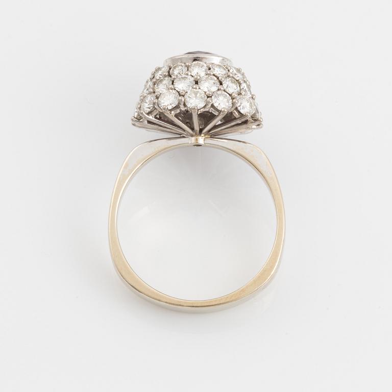 Ring 18K guld med en fasettslipad rubin samt runda briljantslipade diamanter.