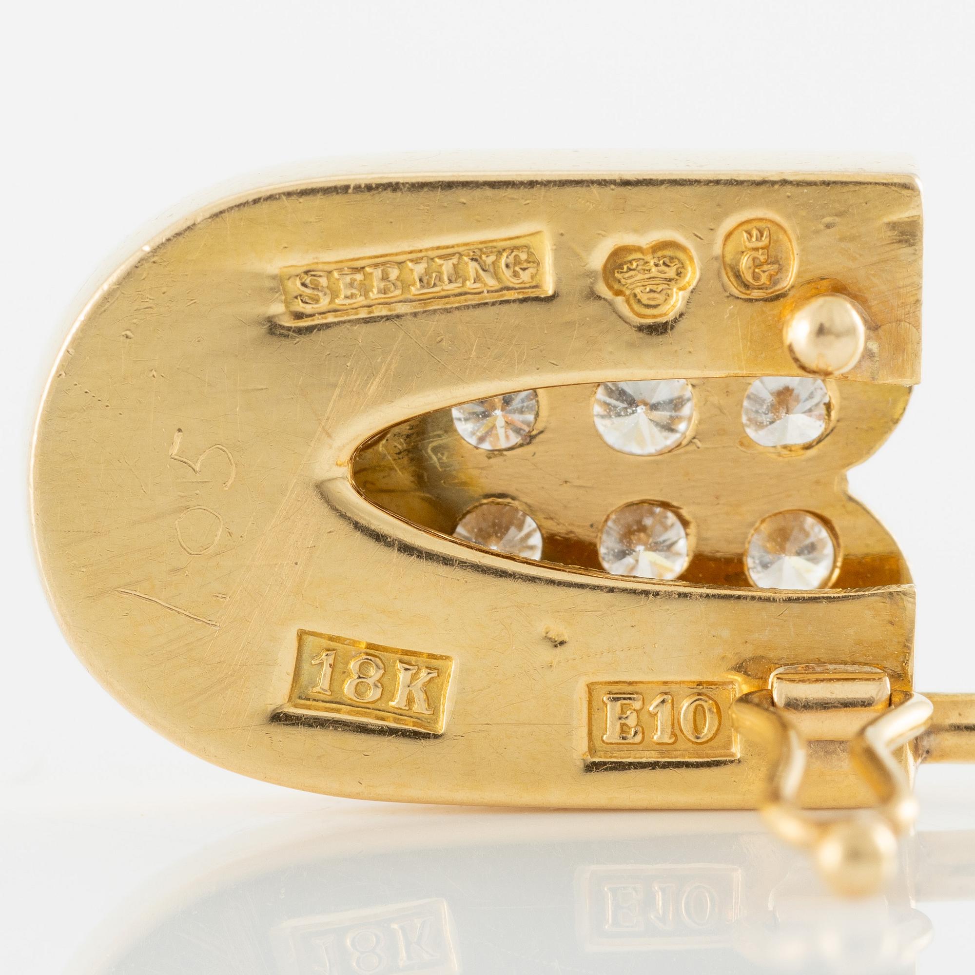 Brosch i form av säkerhetsnål, 18K guld med briljantslipade diamanter.