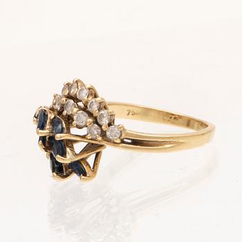 An 18K gold ring with marquise cut sapphires and round brilliant cut diamonds.