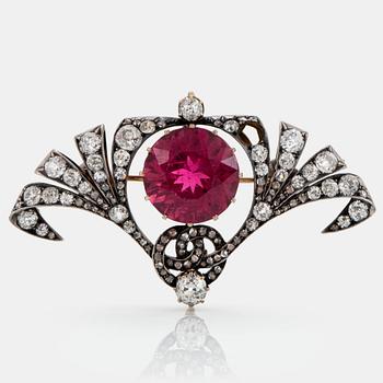 829. A silver and 14K gold brooch set with a faceted pink tourmaline and old- and rose-cut diamonds.