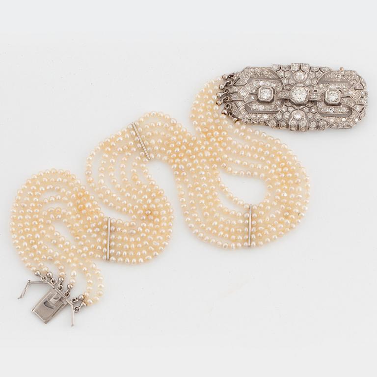 A six strand pearl necklace with a clasp in platinum and 18K white gold set with old- and eight-cut diamonds.