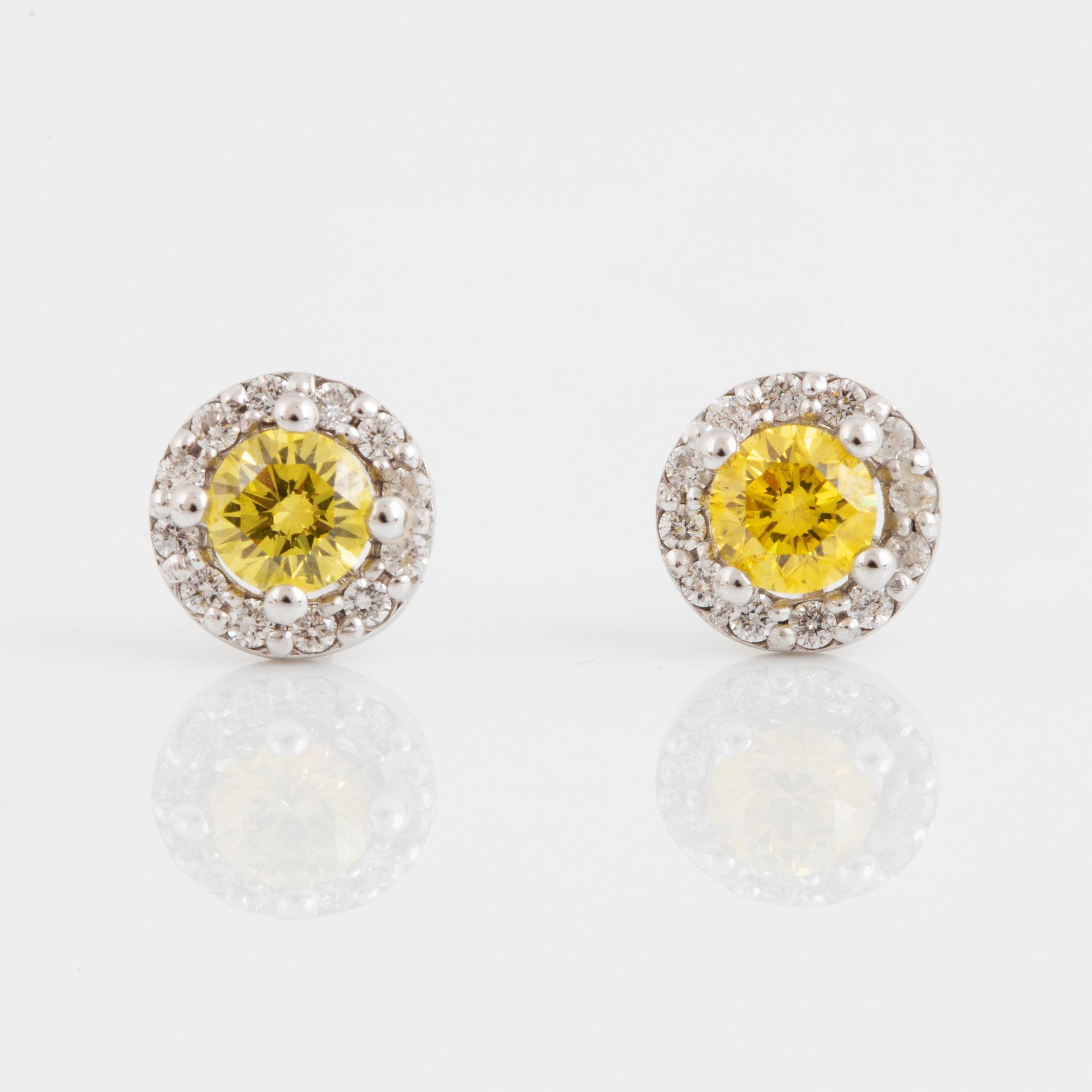 A pair of 18K gold earrings set with color treated yellow diamonds.