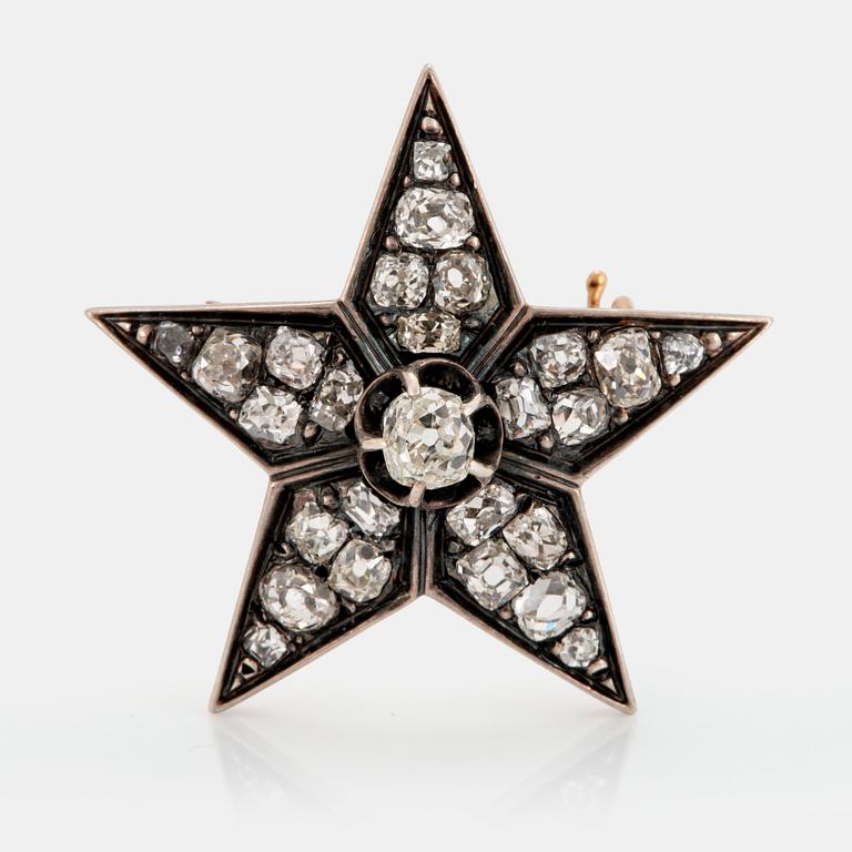 A 14K gold and silver star brooch set with old-cut diamonds.