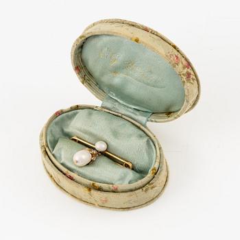 An 18K gold brooch with a drop-shaped pearl.