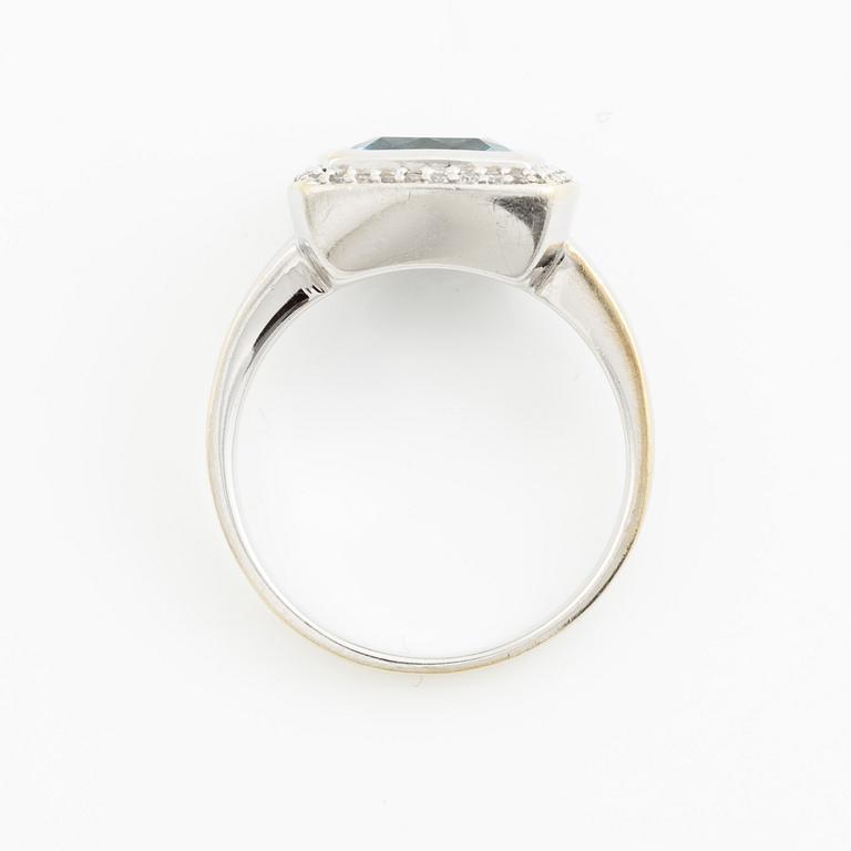 Ring 18K vitguld med en fasettslipad topas och runda briljantslipade diamanter.