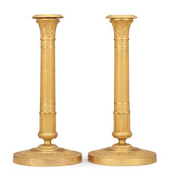 561. A pair of French Empire early 19th century candlesticks.
