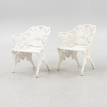 A painted pair of cast aluminum garden armchairs and a table, second part of the 20th Century.