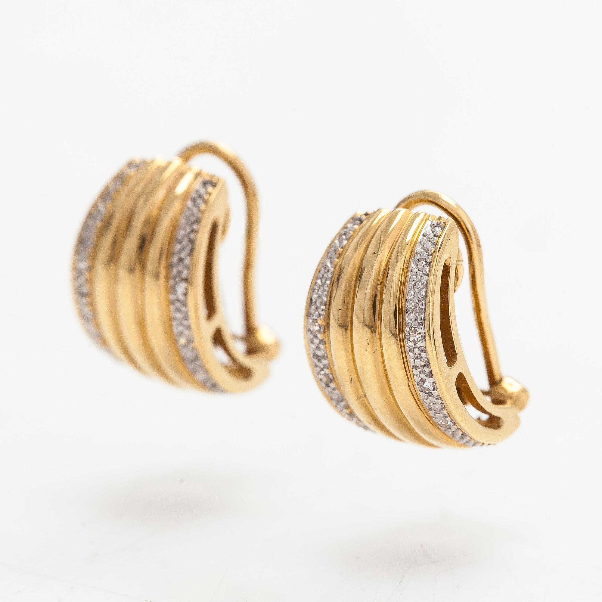 A pair of 18K gold earrings set with small diamonds.