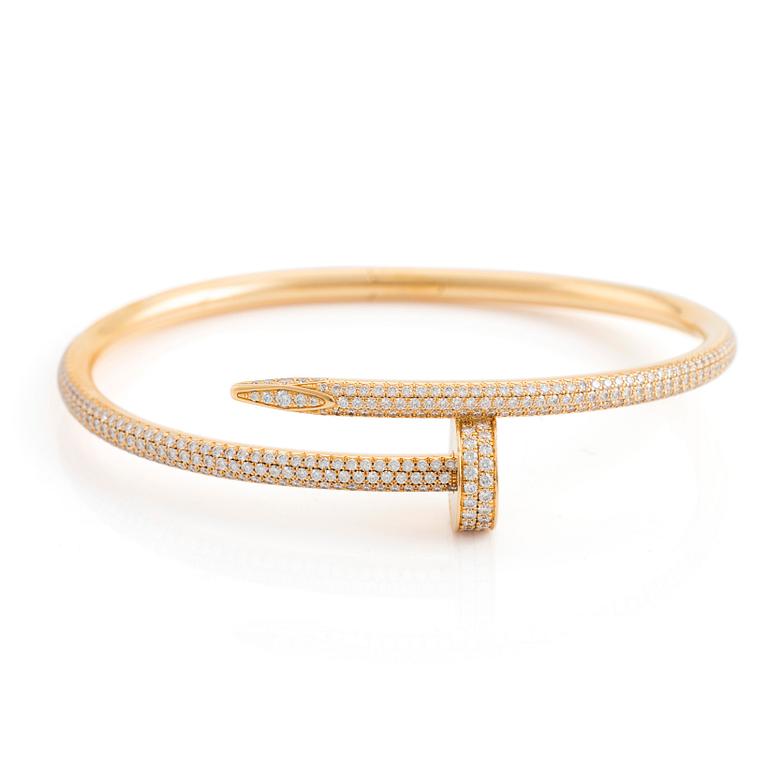 A Cartier "Juste un Clou" bracelet in 18K gold set with round brilliant-cut diamonds.