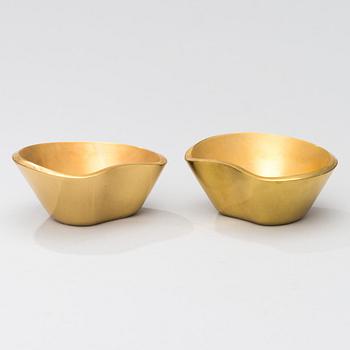 A set of four brass ashtrays, designed in 1947.