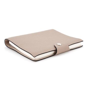 HERMÈS, a taupe veau togo leather notebook, "Ulysse Petit Modèle".