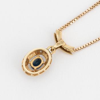 An 18K gold chain and pendant set with an oval, mixed-cut, synthetic sapphire surrounded by eight-cut diamonds.