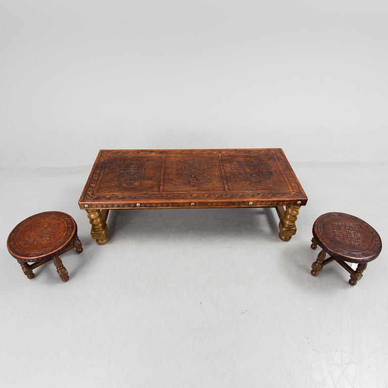 A Peruvian leather covered coffee table and pair of stools, second half of the 20th Century.