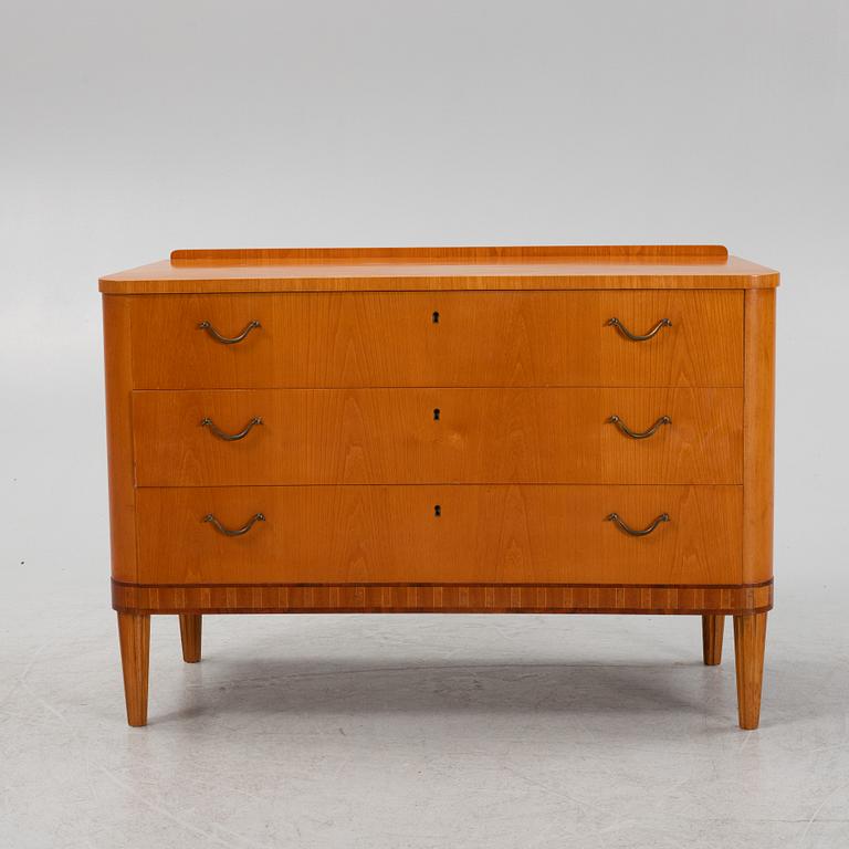 An elm veneered chest of drawers.