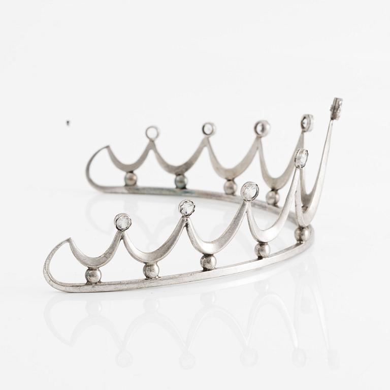 Tiara in silver with white stones.