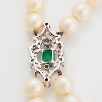 A two strand cultured pearl necklace clasp in 18K white gold set with a faceted emerald.