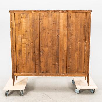 A glass and veneered cabinet from the first half of the 20th century.