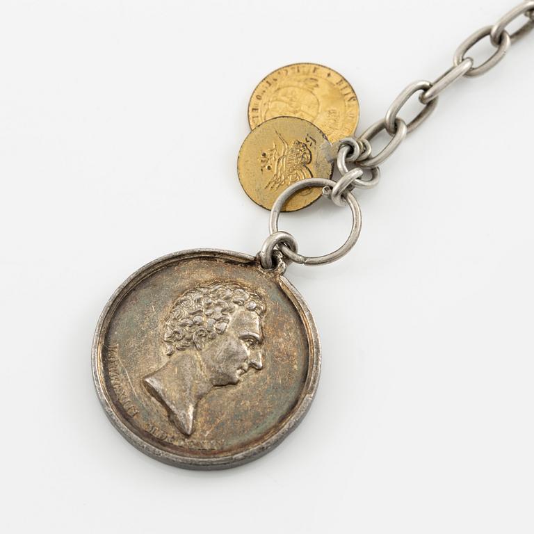 Two bracelets, a brooch, and a pendant with coins.