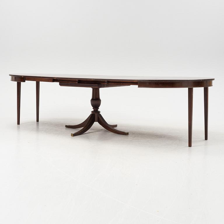 A round mahogany dining table with three additional leaves.