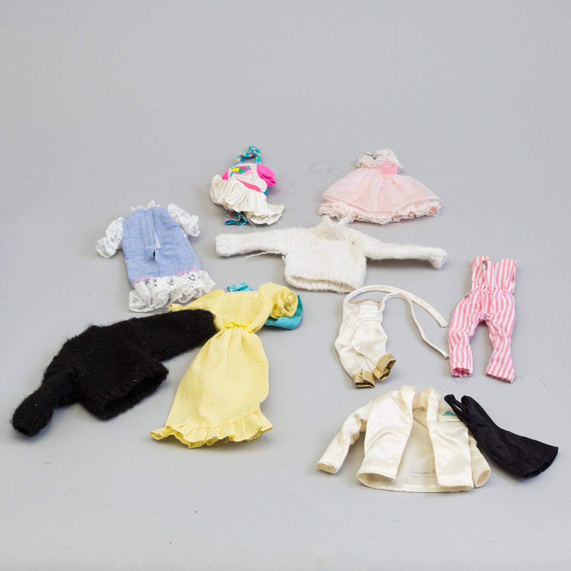 A plastic doll's house with six dolls, furniture and clothes, 20th century.