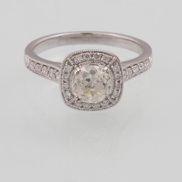 RING, 18K vitguld med äldre briljantslipad diamant ca 1.01 ct samt små briljantslipade diamanter ca 0.26 ct. Vikt 4,2 g.