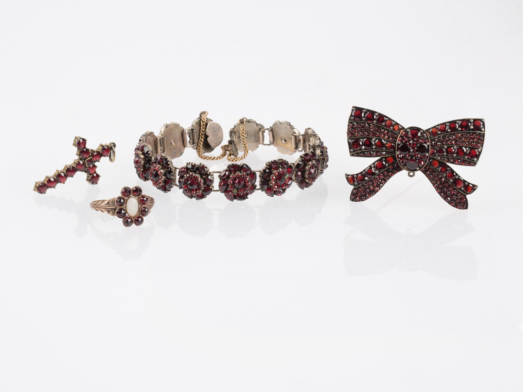 HÄNGE, BROSCH, ARMBAND samt RING, med fasetterade granater, troligen omkring sekelskiftet 1900.