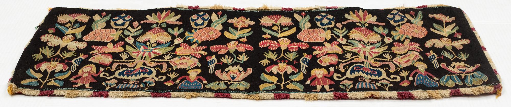 A carrige cushion, "Urnor och par", tapestry weave, ca 105 x 46 cm, around the years 1790-1810.