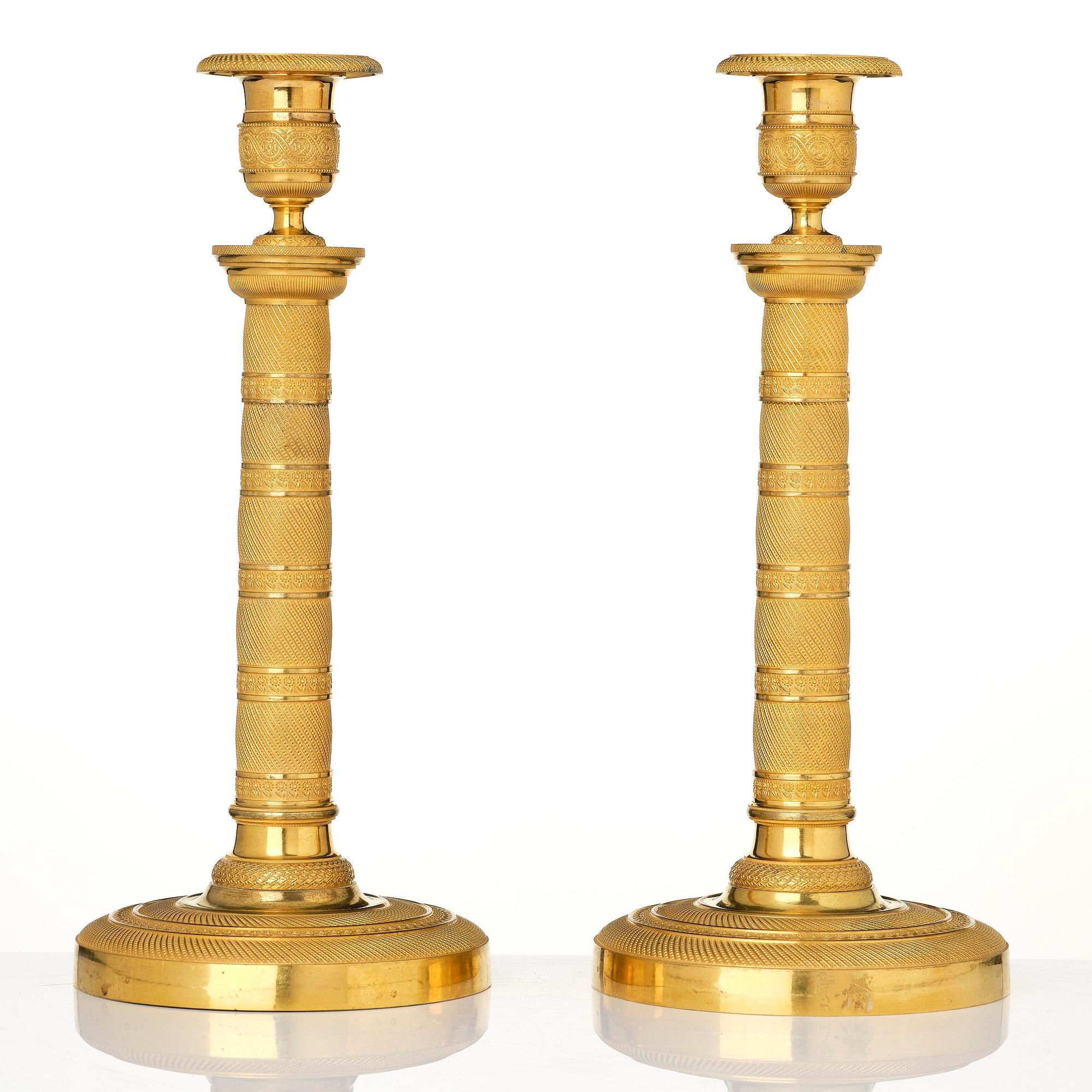 A pair of French Empire gilt-bronze candlesticks, early 19th century.