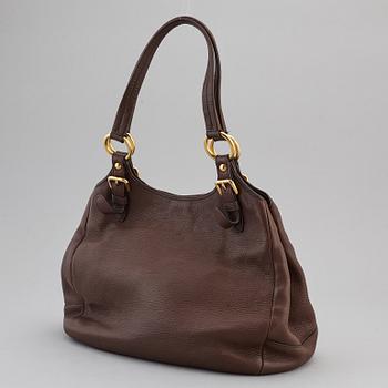 PRADA, a brown leather bag.