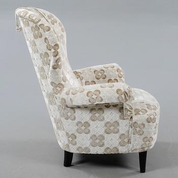 An armchair named "Rundrygg", designed by Carl Malmsten and made by OH Sjögren in 2011.