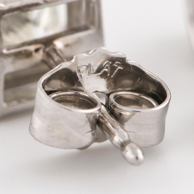 A pair of princess cut diamond earrings.