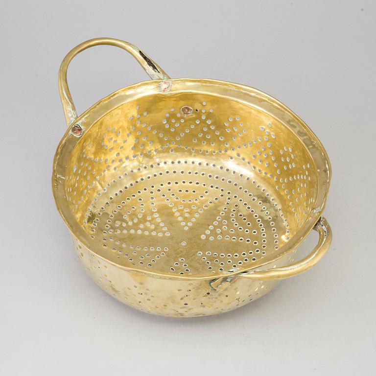 A 19th century brass colander.