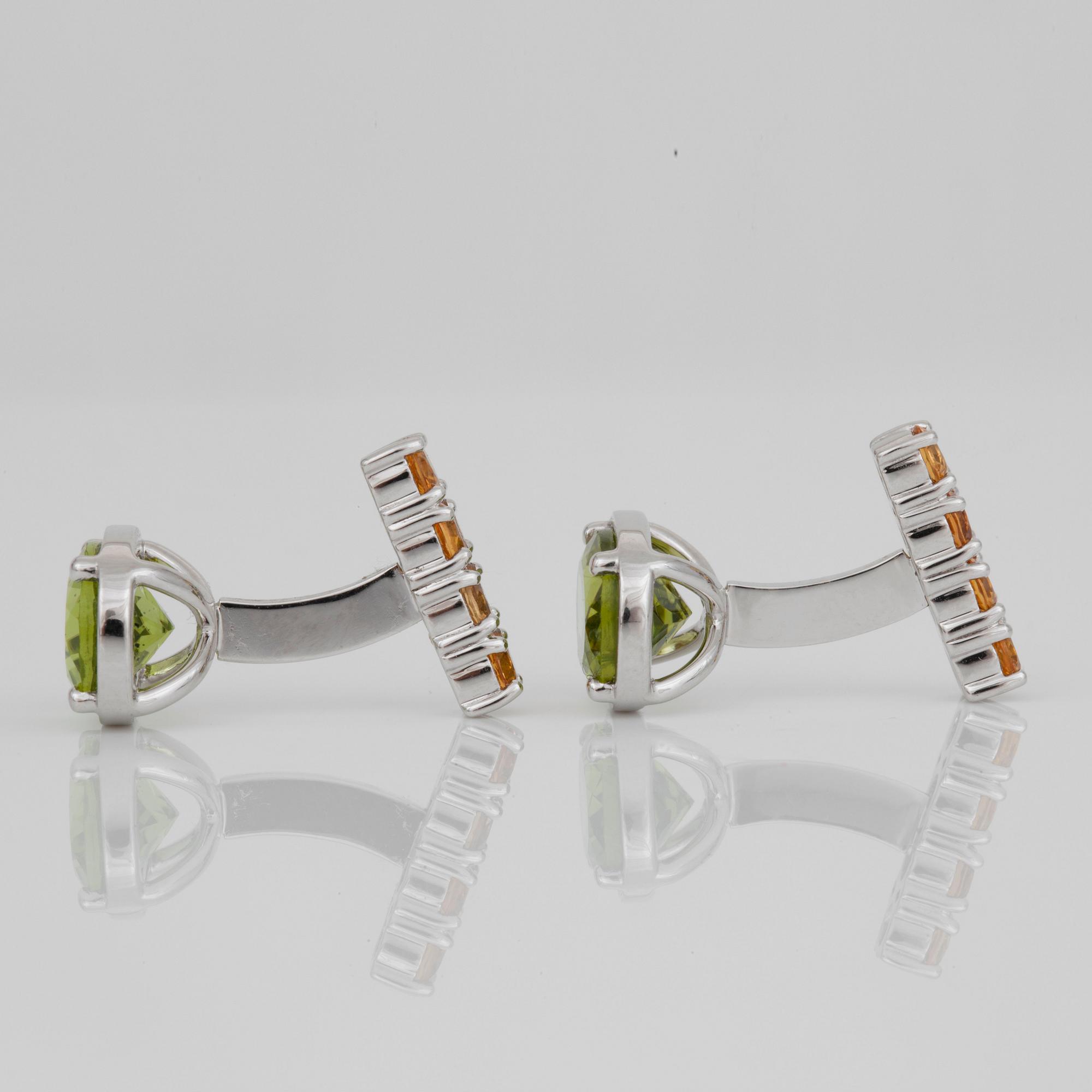A pair of peridot and sapphire cufflinks. Peridots circa 6.10 cts and yellow sapphires circa 1.50 cts in total.