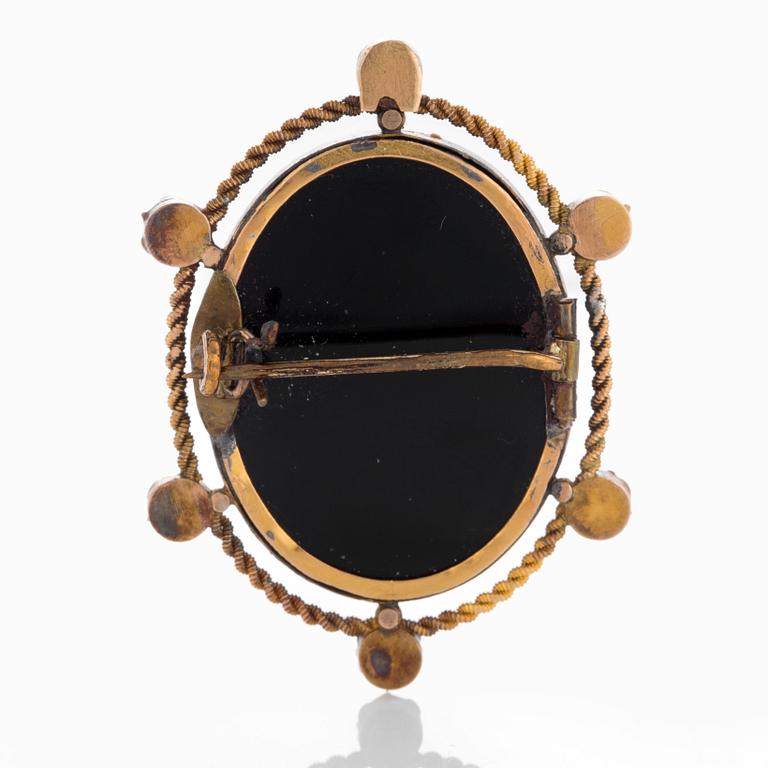 A hard stone cameo brooch in 18K gold set with pearls.