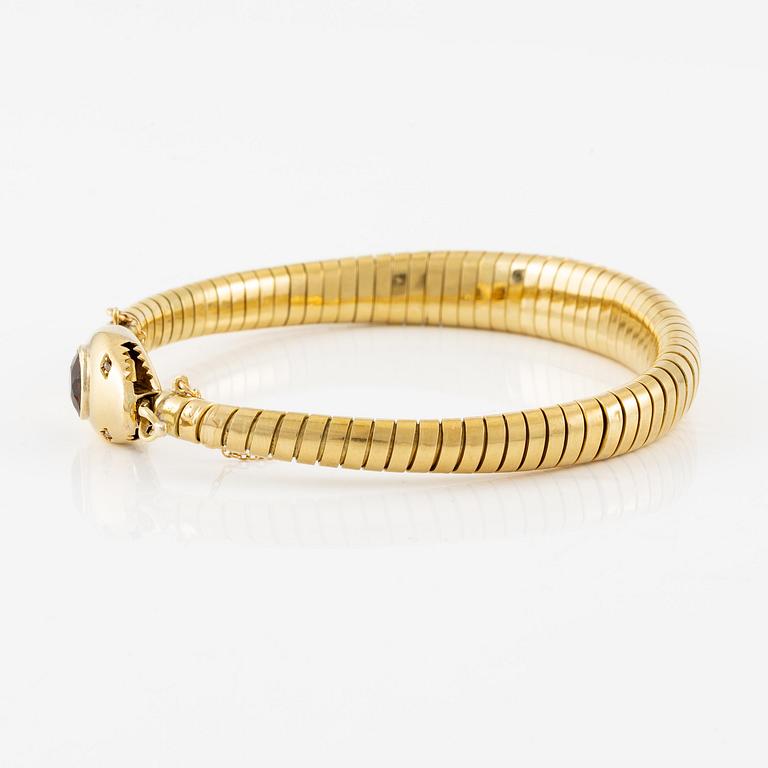 A bracelet in the shape of a serpent in 18K gold with a faceted citrine and rose-cut diamonds.