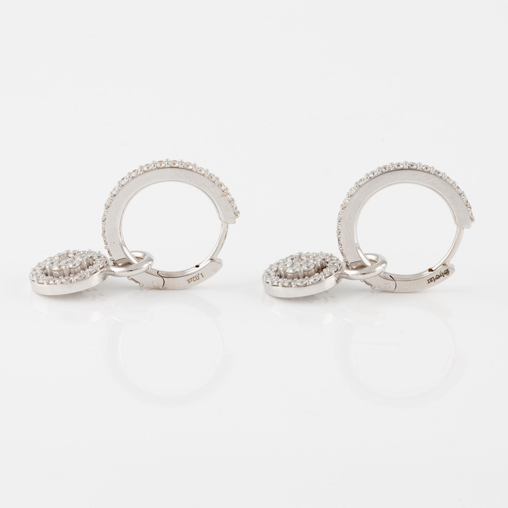 A pair of 18K gold earrings with round brilliant-cut diamonds.