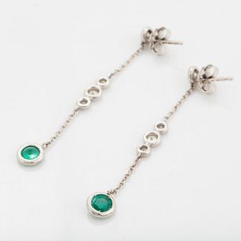 A pair of 18K white gold earrings set with faceted emeralds.