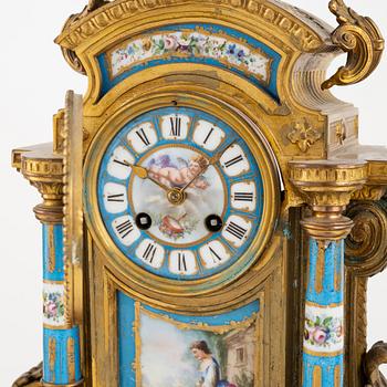 A French mantel clock, two urns and two depicters, second half of the 19th Century.