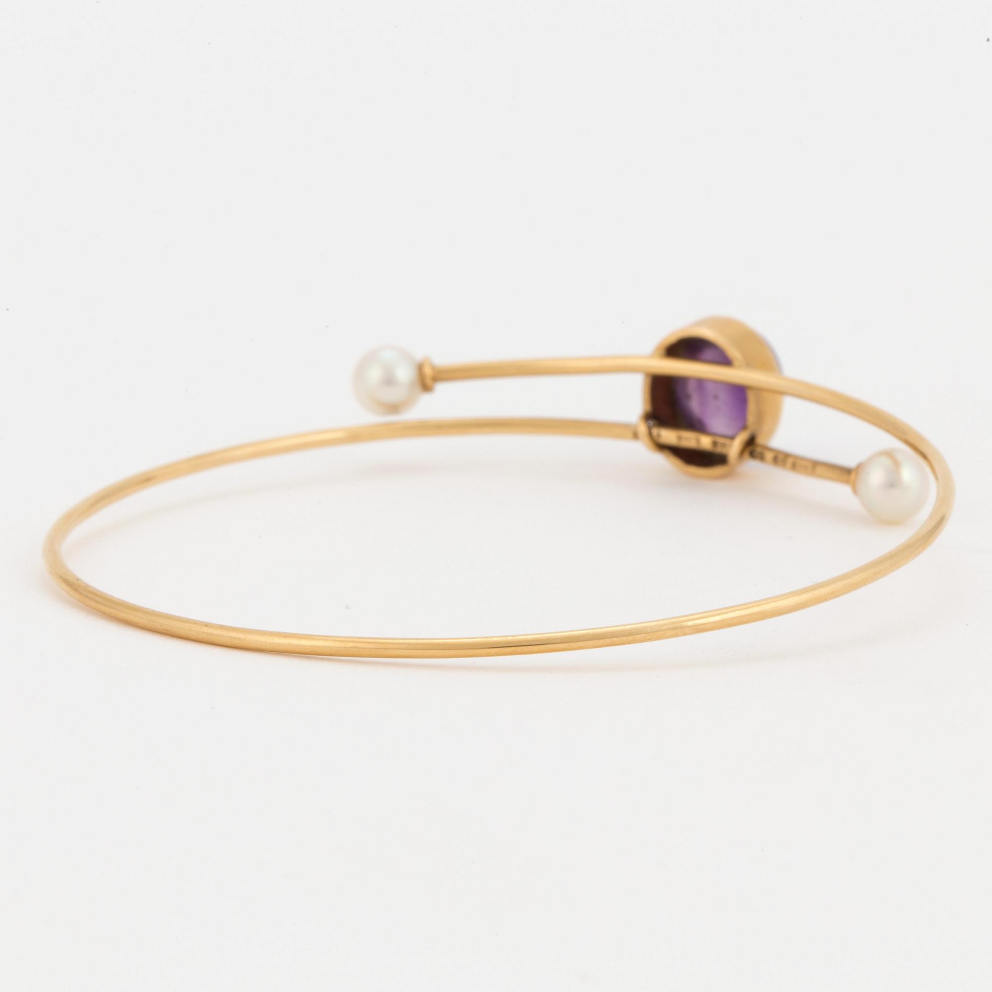 A bangle set with a cabochon-cut amethyst and cultured pearls.
