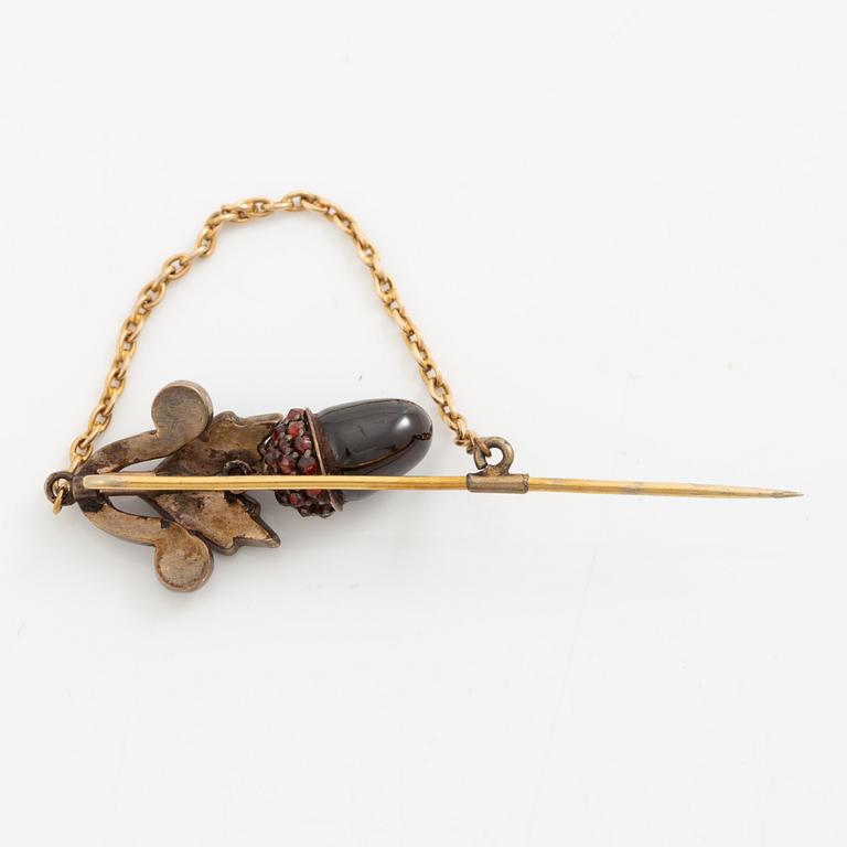 A gold brooch pin set with garnets in the form of acorns, circa 1900.