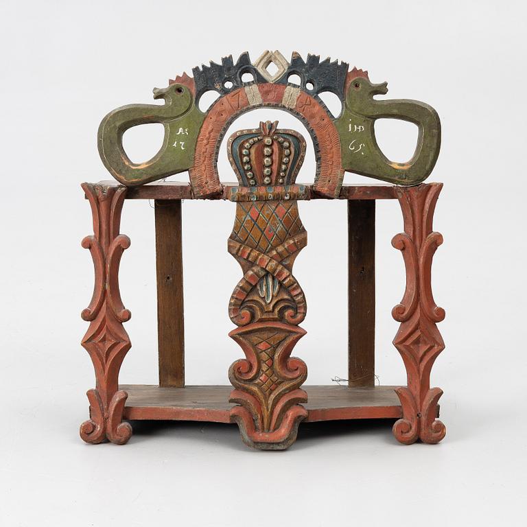 A Swedish carved and painted folk art shelf from Hälsingland, 18th / 19th century.