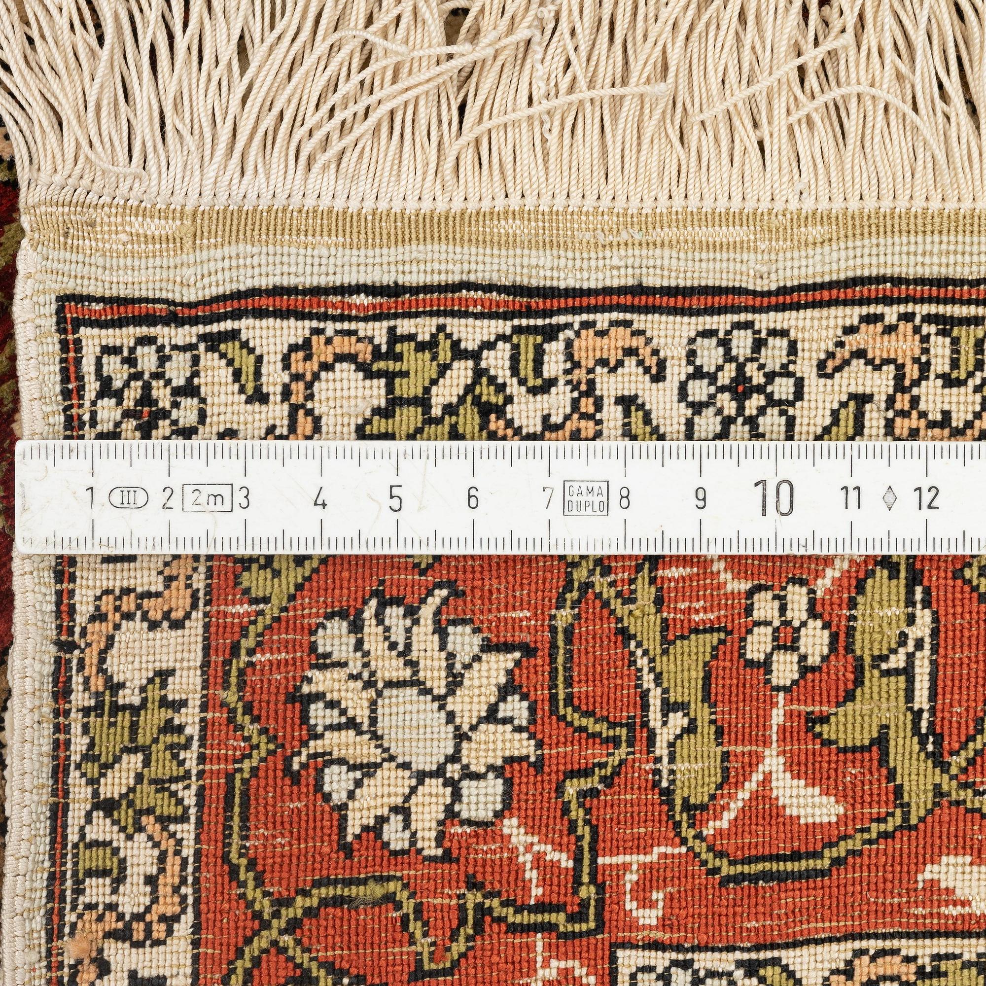 A silk and metal Hereke rug, c. 80 x 51 cm.