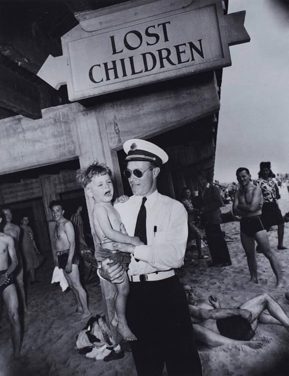 Weegee, "Park Department attendant with lost child, Coney Island, Brooklyn, New York, June 9, 1941".