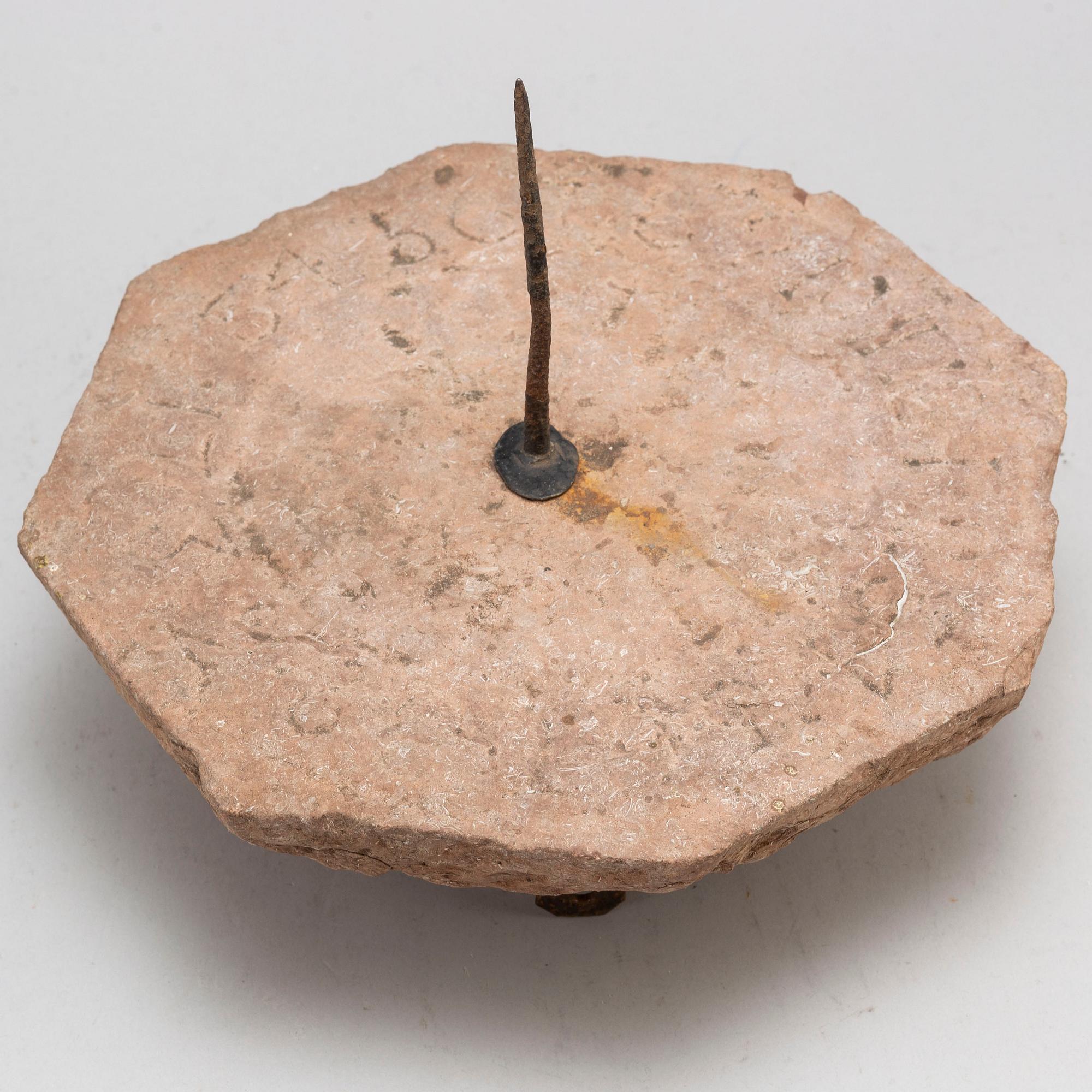 A limestone and iron sundial dated 1732.
