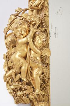 A presumably Dutch Louis XIV carved giltwood frame with mirror glass, in the style of Jean Le Pautre, late 17th century.